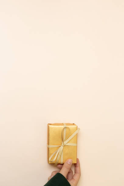 istock Female hand giving gift box on pink background. top view, copy space 1367850892