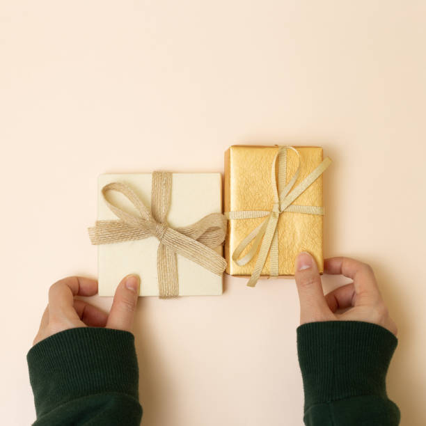 istock Female hand giving gift box on pink background. top view, copy space 1367850906