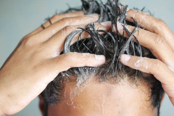 istock young men washes h his hair with shampoo . 1367850938