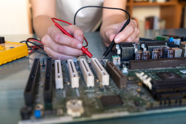 istock Woman hands measuring an computer motherboard electric current 1367852937