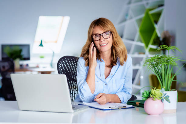 istock Businesswoman using her mobile phone while working at the office 1367853261