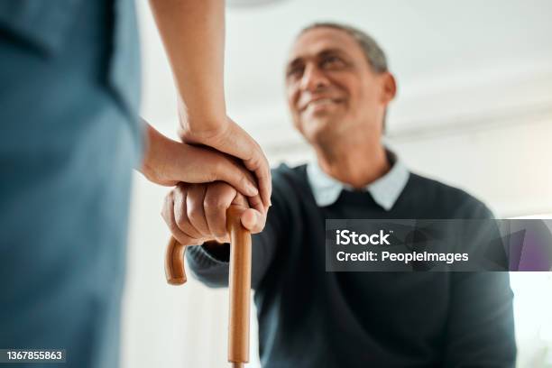 Cropped Shot Of A Nurse Helping An Older Man Stand Up And Use His Walking Stick Stock Photo - Download Image Now
