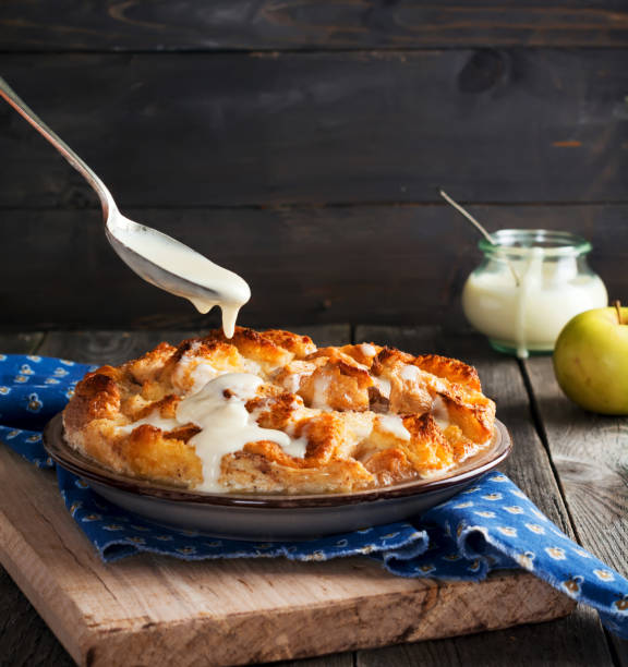 bread pudding. traditional english breakfast casserole with apples and vanilla sauce. bread and butter pudding on old wooden background. selective focus. - healthy eating food and drink nutrition label food imagens e fotografias de stock