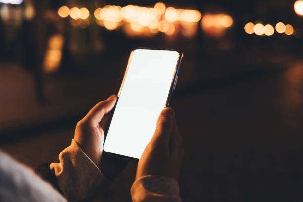 istock Smartphone with blank display in female hands outdoors 1367858820