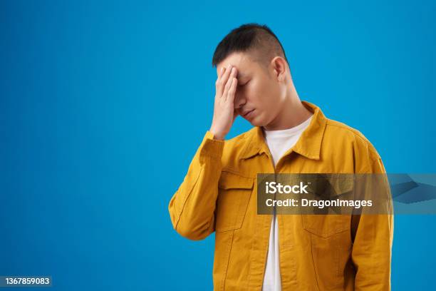 Man Making Face Palm Gesture Stock Photo - Download Image Now - Men, Disappointment, Blue Background