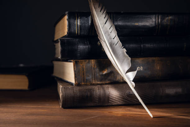 istock Feather with books over wooden desk 1367859447