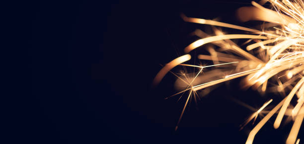 istock Burning christmas sparkler on black background 1367859452