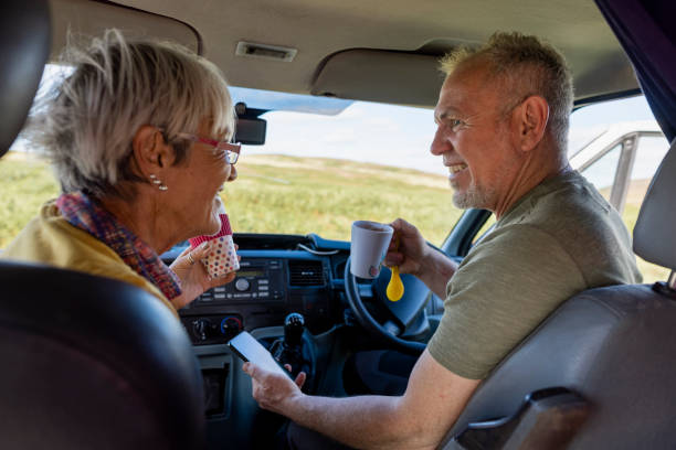 Resting in Their Motor Home A woman and her son sitting in their camper van while on a journey in Rothbury, Northumberland. They are resting after hiking with a cup of tea and are talking with each other. northern europe family car stock pictures, royalty-free photos & images