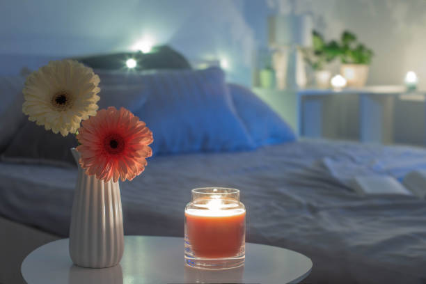 istock gerbers in white vase with burning candle in bedroom  in evening 1367859601