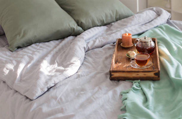 istock tea on wooden tray on bed at home 1367859612