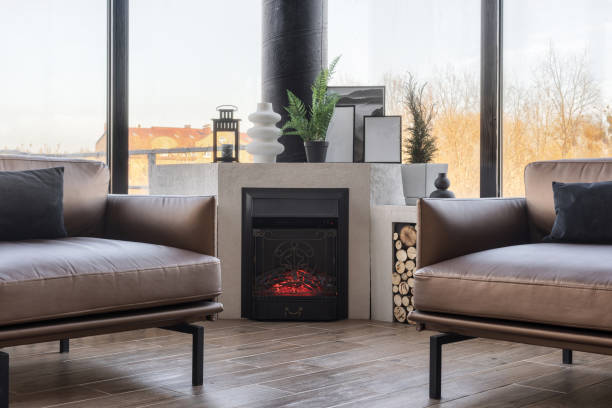 Fireplace and sofas in spacious living room with panoramic windows Modern fireplace and sofas in bright living room. Luxury apartment with panoramic windows. Spacious house for sale. Home comfort. Contemporary interior design fireplace and armchair stock pictures, royalty-free photos & images
