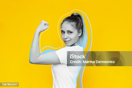 istock Strong powerful confident young blonde woman raises arm showing bicep isolated on a color ackground 1367863247