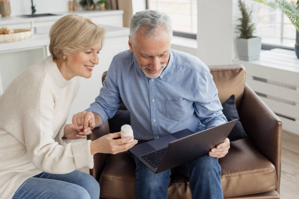 istock Smiling couple holding pills jar and laptop 1367863267