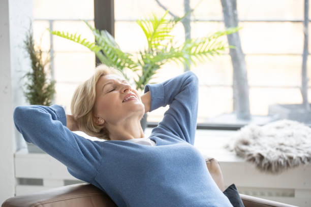 istock Relax senior woman with closed eyes sitting on sofa 1367863270