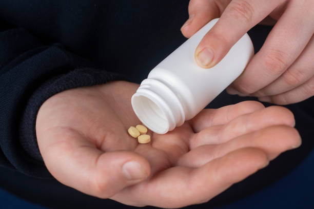 istock A man pours out pills from a plastic jar. 1367866275