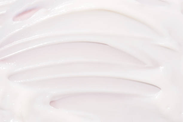 Texture of cream on a pink background.