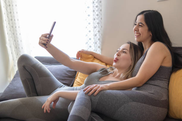 istock Two beautiful young women taking selfies at home 1367868689