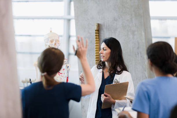istock Female professor lectures and unrecognizable nursing student raises hand 1367871705