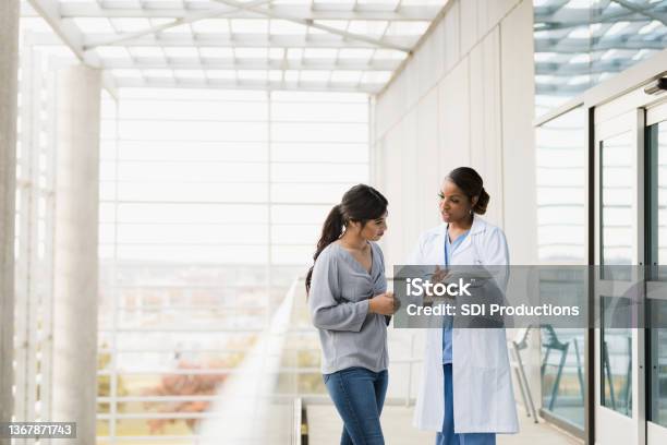 Doctor Explains Patients Test Results To Family Member Stock Photo - Download Image Now