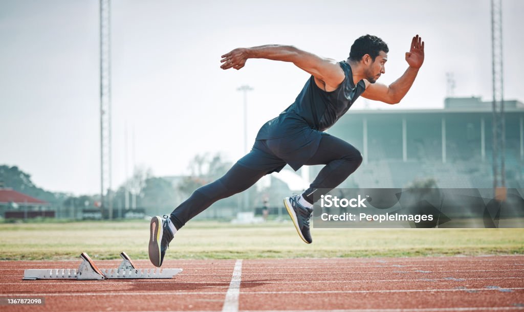 Full length shot of a handsome young male athlete running on an outdoor track Pace off the line Sprinting Stock Photo