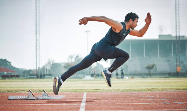 pełnometrażowe ujęcie przystojnego młodego sportowca biegnącego po torze plenerowym - athlete zdjęcia i obrazy z banku zdjęć