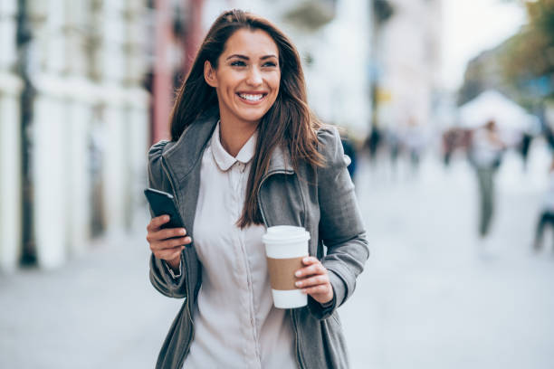 istock Young woman using smartphone on the street. 1367872513