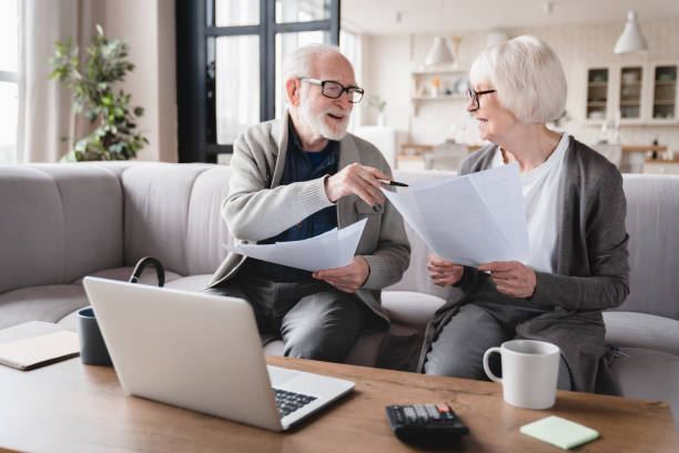 vieux grands-parents âgés âgés couple femme de famille et mari comptant les fonds, déclarations d’épargne, investissements, paperasse, documents financiers, faillite, affaire judiciaire, factures, pension avec ordinateur portable. - senior couple senior adult pension couple photos et images de collection