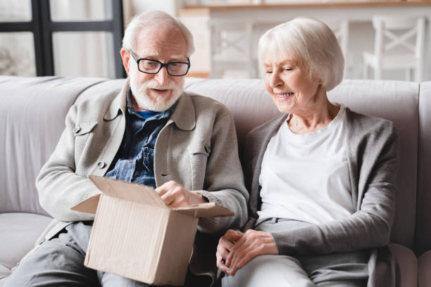 après la livraison. vieux vieux couple de grands-parents de famille ouvrant un colis avec de nouveaux vêtements, marchandises, recevoir des cadeaux cadeaux, commander sur internet. - affaires personnelles photos et images de collection