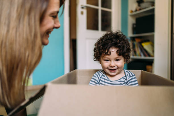 istock Little boy playing in cardboard box during relocation. 1367874080