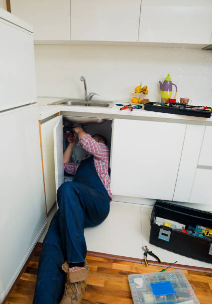 istock Handyman Lying On Floor Repairing Sink In Kitchen 1367874220