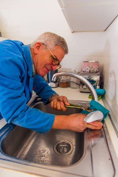 istock Repairman fixing the faucet with tools 1367875662