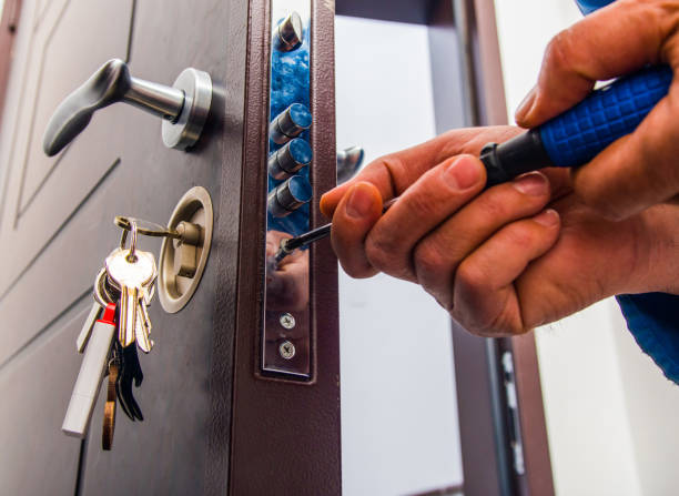 istock Handyman repairs the door lock 1367876171