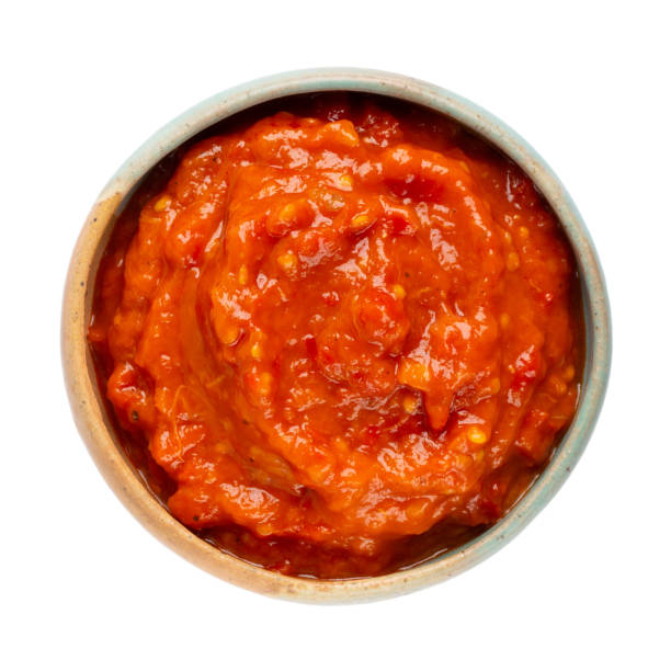 ajvar - tradição molho de pimenta vermelha assada sérvia em tigela de cerâmica isolada em branco.  prato lateral ou espalhe no pão de pimentão doce, berinjela e alho. vista superior. - sauces sweet sauce cooking traditional culture - fotografias e filmes do acervo