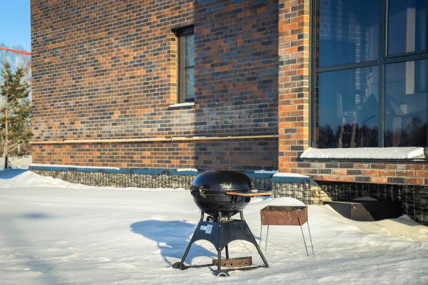 Barbecue and old brazier on the street in winter near the house. Outdoors stock photo