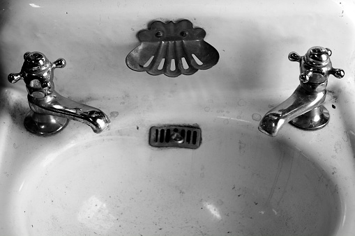 Old fashioned antique vintage bathroom sink and faucets for hot and cold water