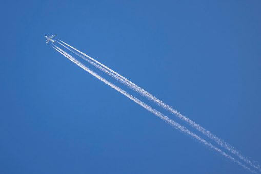 A plane in the sky leaving a contrail