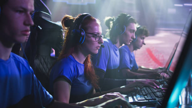 istock Focused woman playing video game with teammates 1367880423
