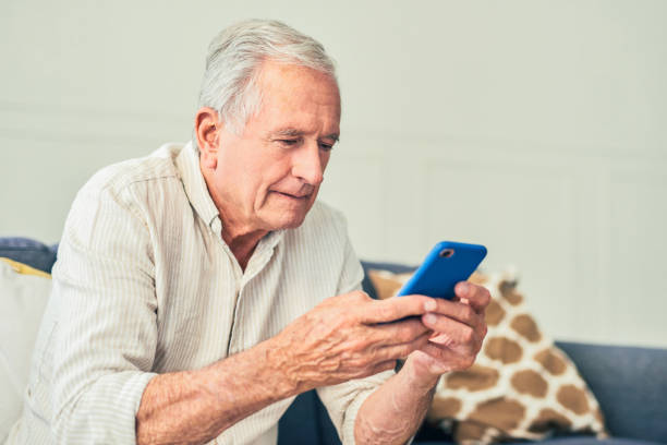 istock Shot of a senior man using his cellphone while sitting at home 1367880678