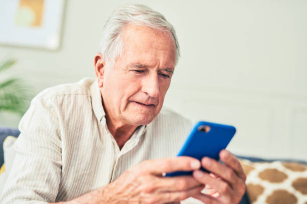 istock Shot of a senior man using his cellphone while sitting at home 1367880683