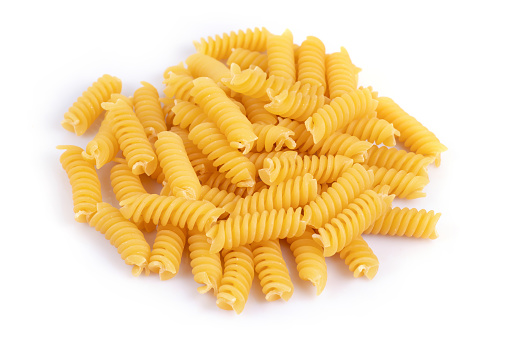 Variety of types and shapes of dry Italian pasta on white background.