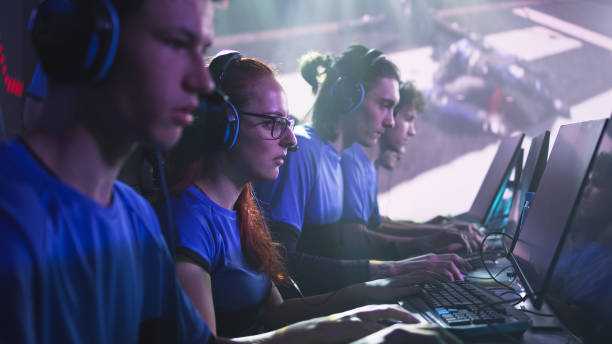 istock Focused men and women playing video game during competition 1367882087