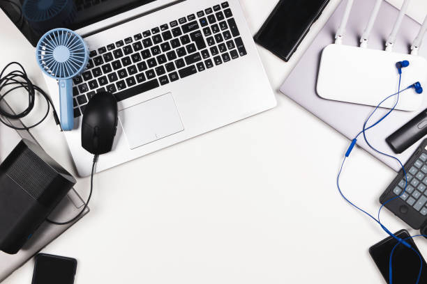 istock Top view to old laptop computers, digital tablets, mobile phones, many used electronic gadgets devices on white table. Planned obsolescence, e-waste, electronic waste for recycling concept 1367882784