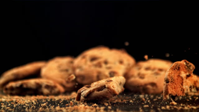 Cookies with pieces of chocolate fall on the table. Filmed is slow motion 1000 fps.