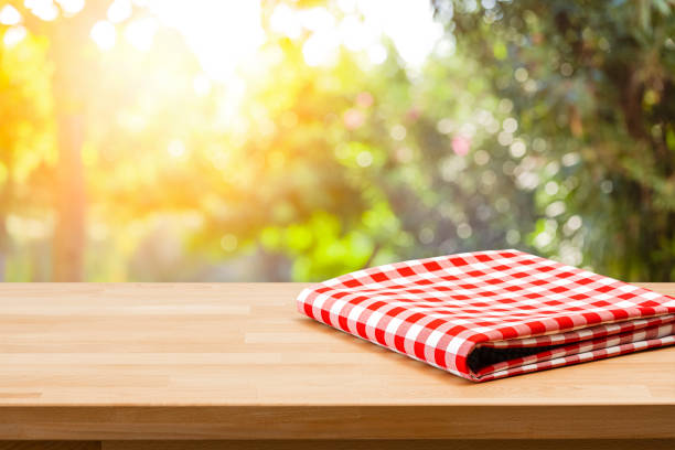 istock Table with folded picnic blanket and nature background 1367883485