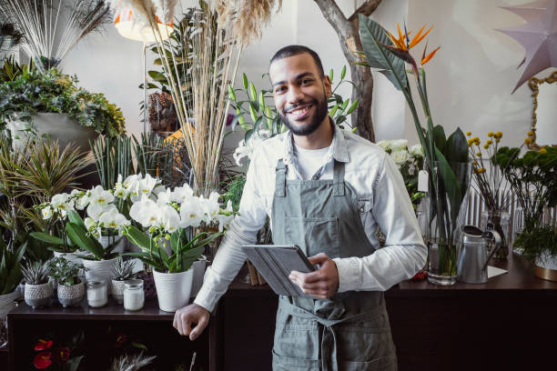 porträt eines blumenhändlers, der im blumenladen arbeitet - flower shop stock-fotos und bilder