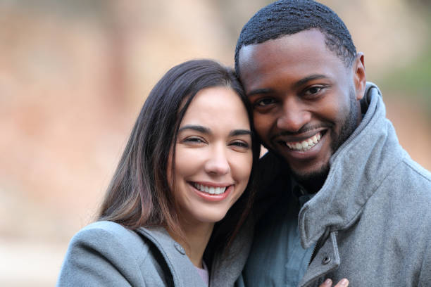 istock Happy interracial couple looking at camera in winter 1367884617