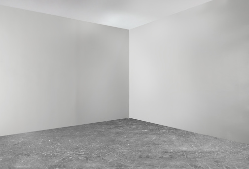 An empty garage room corner with a concrete floor
