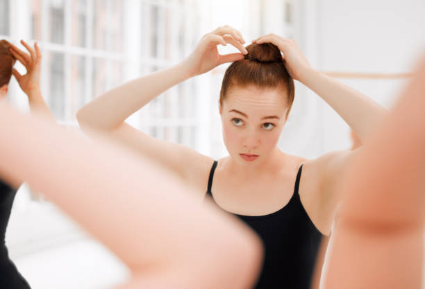 Shot of a group of ballet dancers fixing their hair together before rehearsing their routine The teenage queen, the loaded gun hair bun stock pictures, royalty-free photos & images