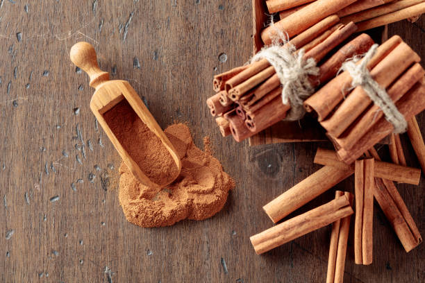istock Cinnamon sticks and powder on a wooden table. 1367886904