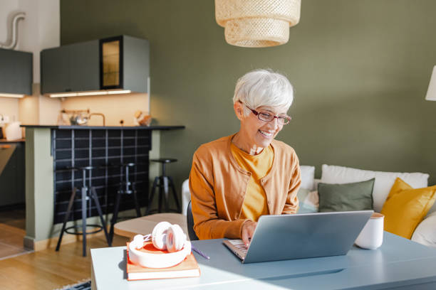 istock Senior woman working on her laptop at home 1367887832